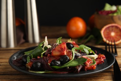 Photo of Delicious salad with sicilian orange on wooden table, closeup