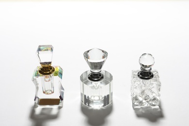 Photo of Different elegant perfume bottles on white background