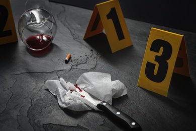 Crime scene markers and evidences on black background, closeup