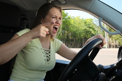 Emotional woman in car. Aggressive driving behavior