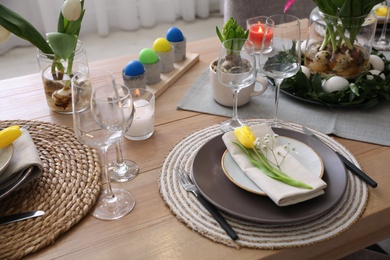 Photo of Beautiful Easter table setting with beautiful flowers indoors