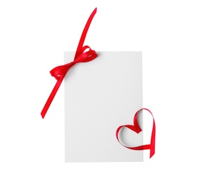 Blank card with bow and heart made of red ribbon on white background, top view. Valentine's Day celebration