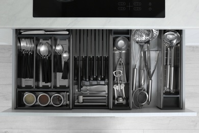 Drawer with stainless steel utensil set, top view. Order in kitchen