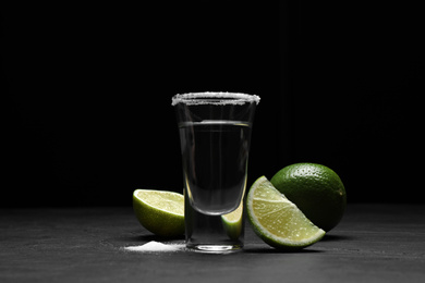 Mexican Tequila shot with salt and lime on black table
