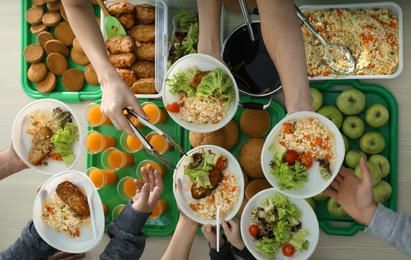 Volunteers serving food for poor people indoors, view from above