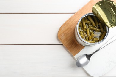 Canned green beans on white wooden table, top view. Space for text