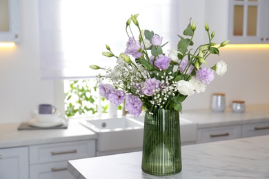 Beautiful bouquet with Eustoma flowers on table in kitchen