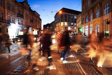 People crossing city street at night, long exposure effect