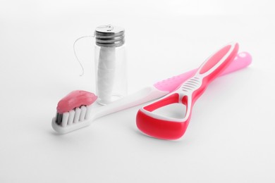 New tongue cleaner, dental floss and toothbrush with paste on white background