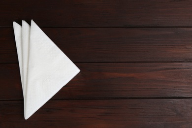 Clean napkins on wooden table, top view. Space for text