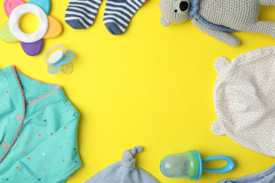 Flat lay composition with child's clothes and accessories on yellow background, space for text