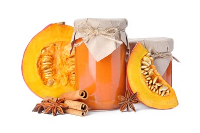 Jars of pumpkin jam, star anise, fresh pumpkin and cinnamon on white background