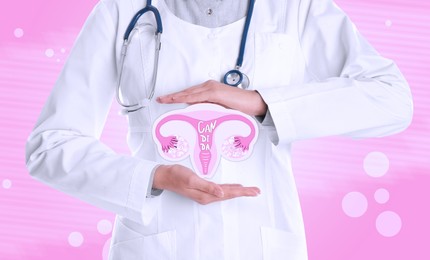 Doctor demonstrating virtual image of infected female reproductive system on pink background, closeup. Vaginal candidiasis