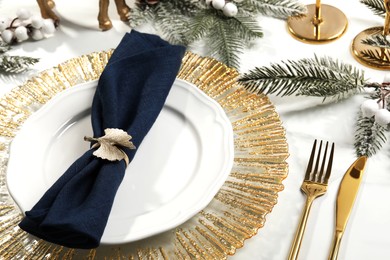 Stylish table setting with dark blue fabric napkin, beautiful decorative ring and festive decor