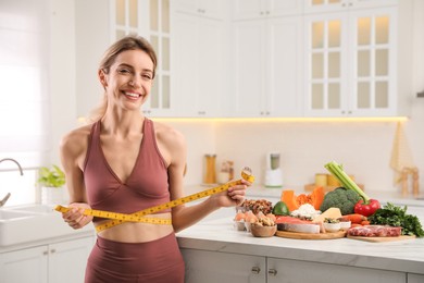Woman with measuring tape and different products in kitchen. Keto diet