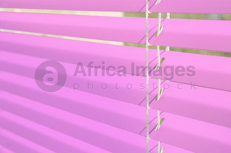Image of Window with pink horizontal blinds, closeup view