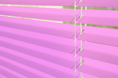Window with pink horizontal blinds, closeup view