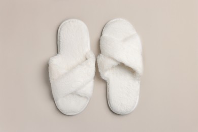 Pair of soft fluffy slippers on light grey background, top view