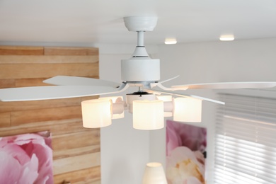 Modern ceiling fan with lamps indoors. Interior element