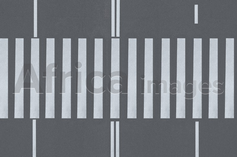White pedestrian crossing on empty city street, top view