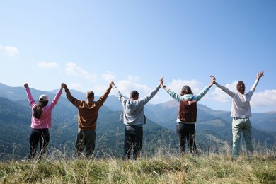 Photo of Group of people spending time together in mountains, back view