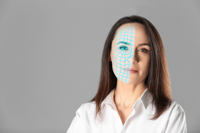 Facial recognition system. Mature woman with digital biometric grid on grey background