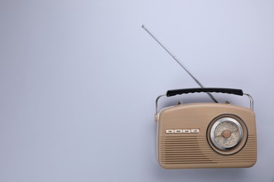 Retro radio receiver on light grey background, top view. Space for text