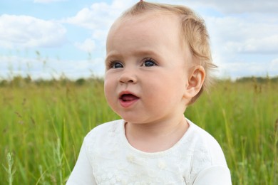 Portrait of adorable little baby in green field