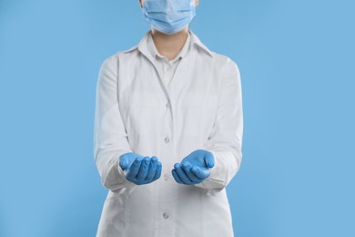 Dentist holding something on light blue background, closeup
