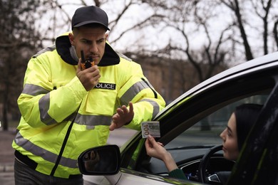 Police officer rejecting bribe near car outdoors