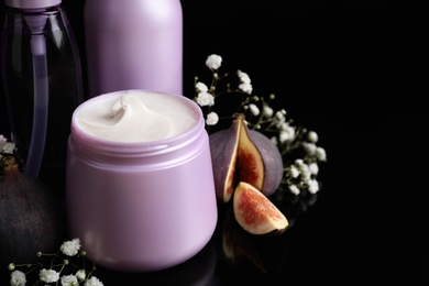 Set of hair cosmetic products, flowers and figs on  black background, closeup