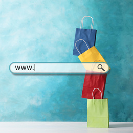 Online shopping. Search bar and colorful paper bags on background