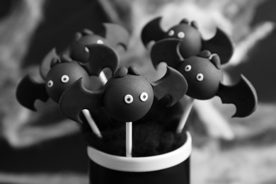 Bat shaped cake pops on dark background, closeup. Halloween treat