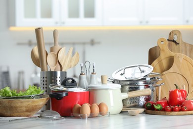 Set of cooking utensils and products on white table against blurred background