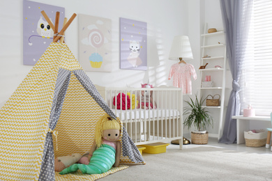 Baby room interior with cute posters, play tent and comfortable crib