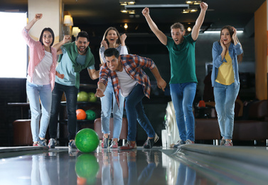 Photo of Man throwing ball and spending time with friends in bowling club