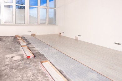 Light spacious room with unfinished laminate flooring
