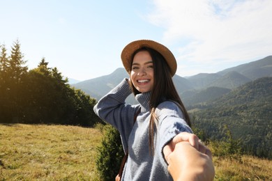 Young woman with her boyfriend in mountains on sunny day