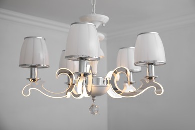 Photo of Stylish chandelier on ceiling in light room