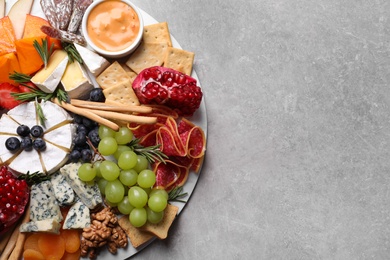 Assorted appetizers served on light grey table, top view. Space for text