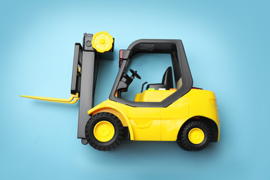 Top view of toy forklift on blue background. Logistics and wholesale concept
