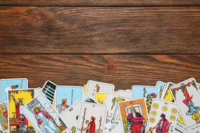 Tarot cards on wooden table, top view. Space for text