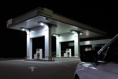 Modern car driving to gas station at night, closeup