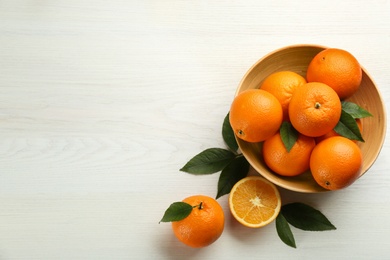 Delicious ripe oranges on white wooden table, flat lay. Space for text