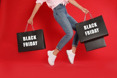 Woman with shopping bags on red background, closeup. Black Friday