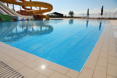Photo of Outdoor swimming pool with clear water on sunny day. Summer vacation