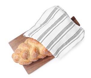 Homemade braided bread with sesame seeds and napkin isolated on white, top view. Traditional Shabbat challah