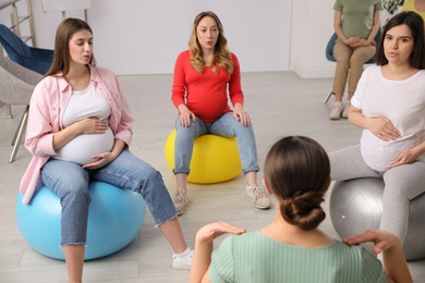 Group of pregnant women with trainer at courses for expectant mothers indoors