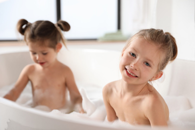 Cute little sisters taking bubble bath together
