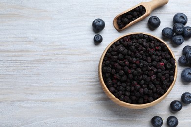 Freeze dried and fresh blueberries on white wooden table, flat lay. Space for text